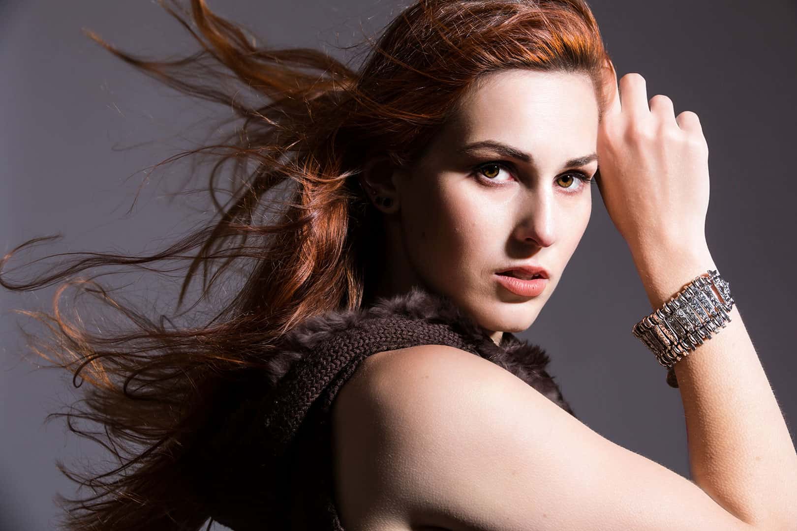 dramatic studio fashion image of woman with hair blowing