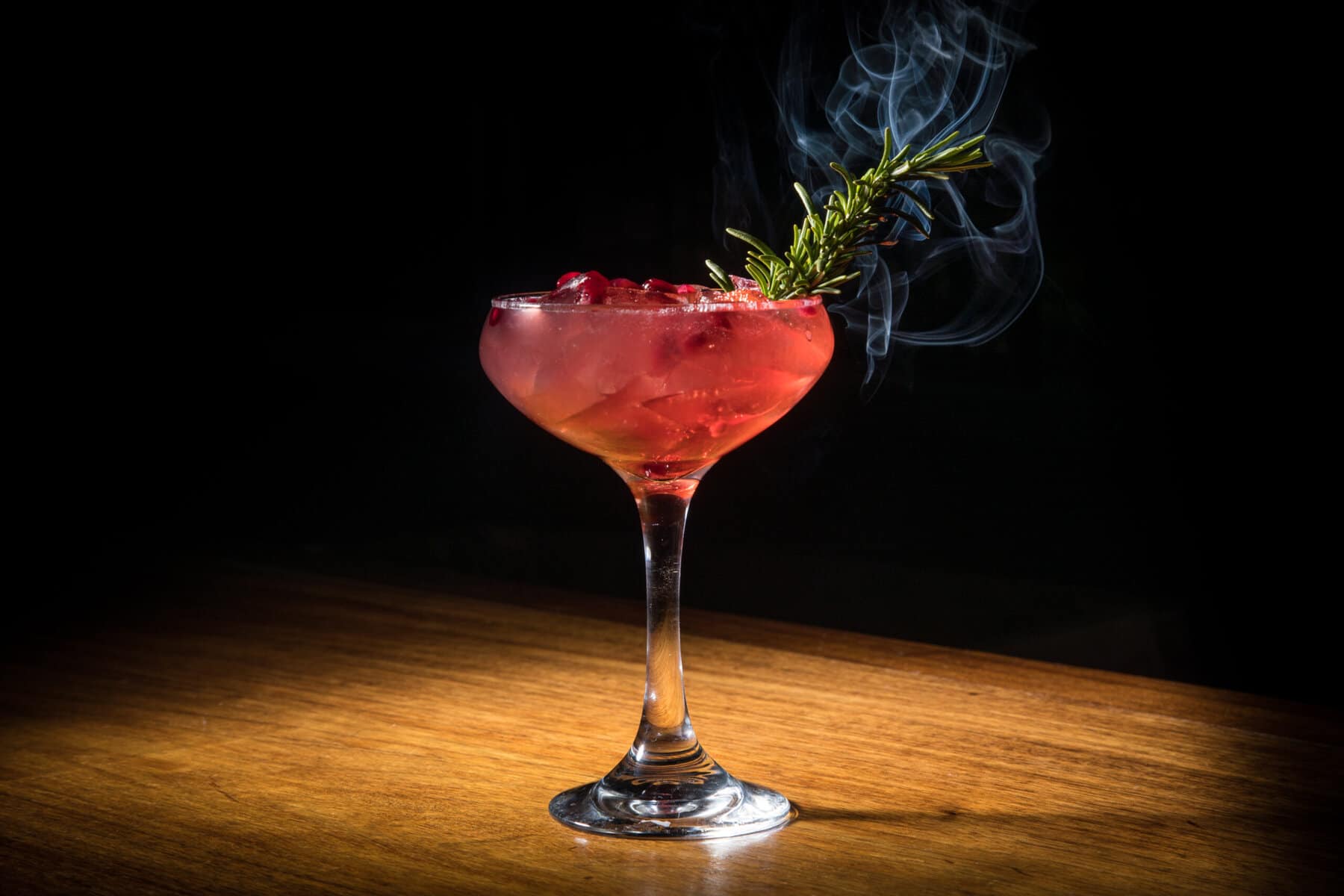 cocktail with smoking rosemary sprig